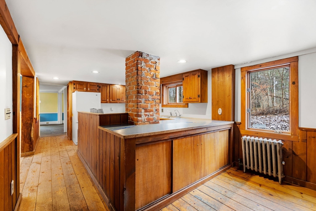 104 Mill Street Groton, MA 01450 - Photo 7 of 30 a kitchen with stainless steel appliances granite countertop a sink and a wooden floor
