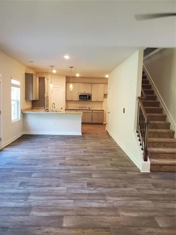 a view of a kitchen with wooden floor and a window