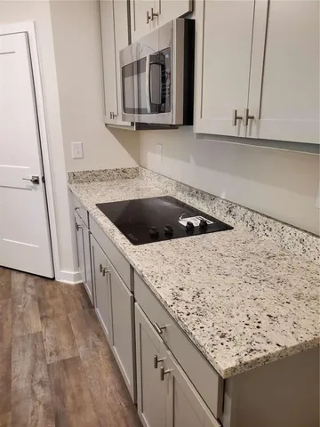 a kitchen with granite countertop white cabinets and sink