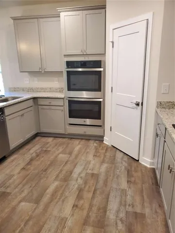 a kitchen with granite countertop white cabinets and white appliances