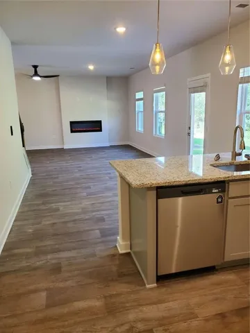 a kitchen with kitchen island granite countertop a sink window and wooden floor
