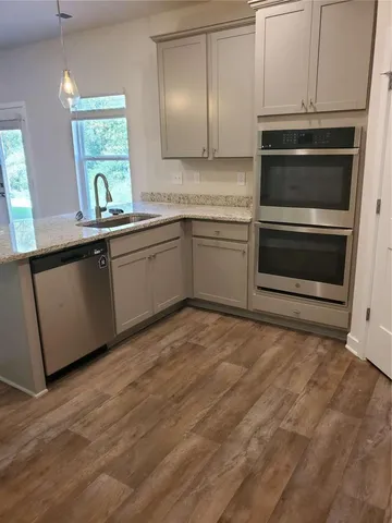 a kitchen with granite countertop a stove sink and cabinets