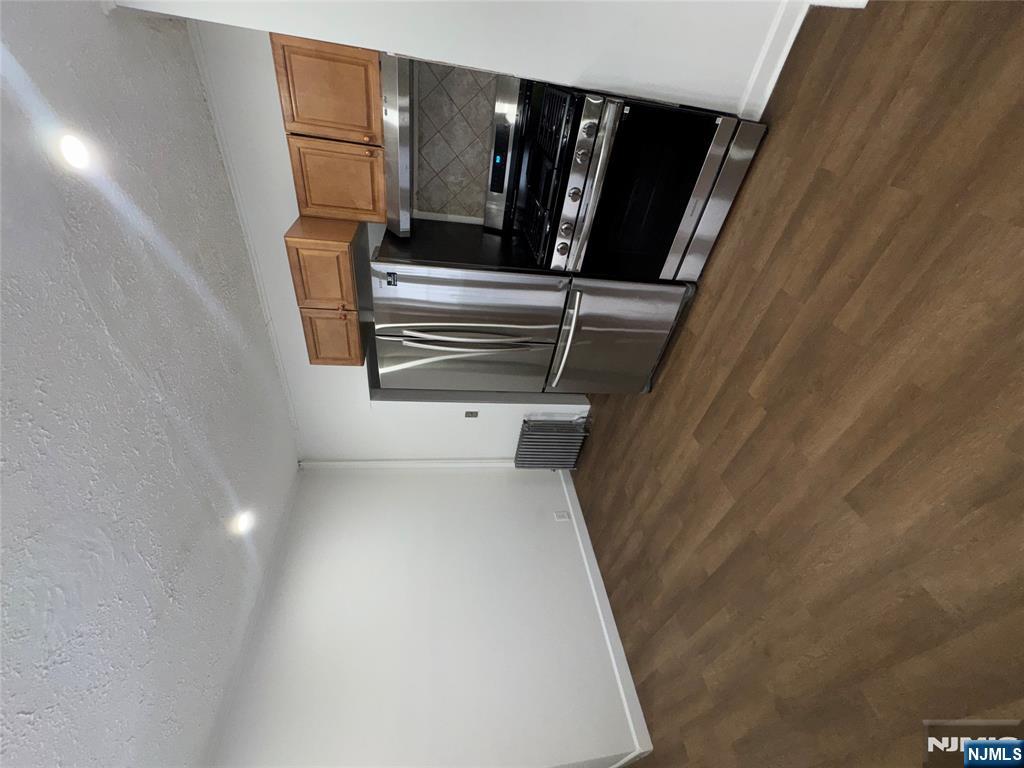 438 4th Street, Unit 1 Carlstadt, NJ 07072 - Photo 3 of 11 a kitchen with granite countertop a refrigerator and a stove top oven