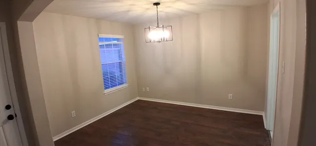 a view of a hallway with windows and chandelier