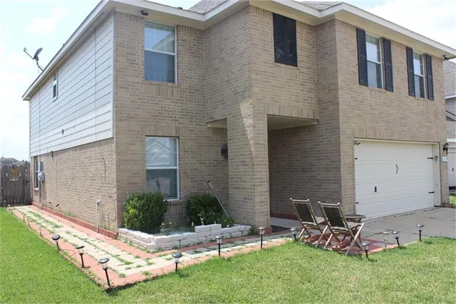 a view of a chair and table in backyard of the house