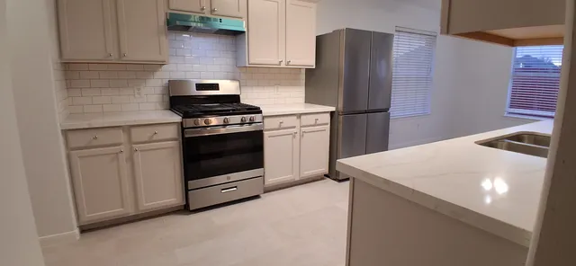 a kitchen with stainless steel appliances a refrigerator sink and stove