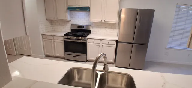 a kitchen with stainless steel appliances a refrigerator stove and sink