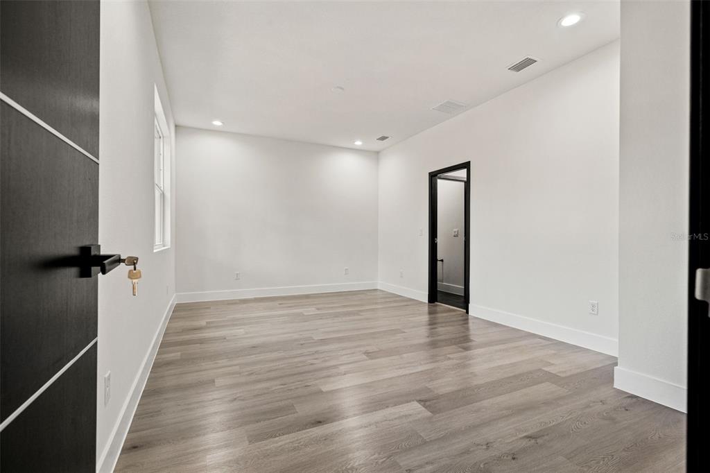 2956 West Higgins Place Dunnellon, FL 34433 - Photo 25 of 52 a view of an empty room with wooden floor and a bathroom