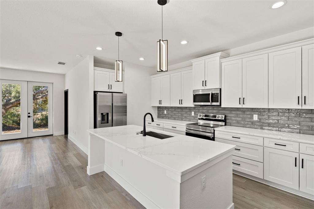2956 West Higgins Place Dunnellon, FL 34433 - Photo 9 of 52 a kitchen with stainless steel appliances a stove refrigerator sink and cabinets