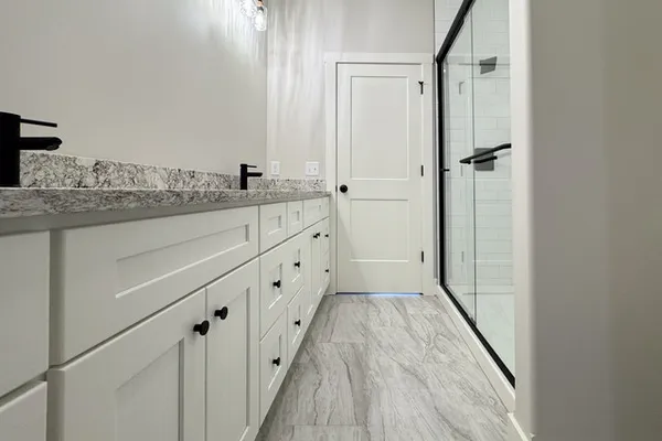 a bathroom with granite countertop a sink and a mirror