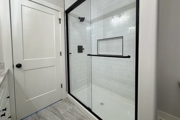 a bathroom with a shower and mirror