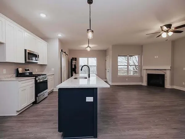 a kitchen with kitchen island a sink stainless steel appliances and window