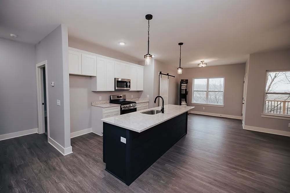 609 Anjali Court, Unit L Sycamore, IL 60178 - Photo 4 of 20 a kitchen with kitchen island granite countertop a sink appliances and wooden floor