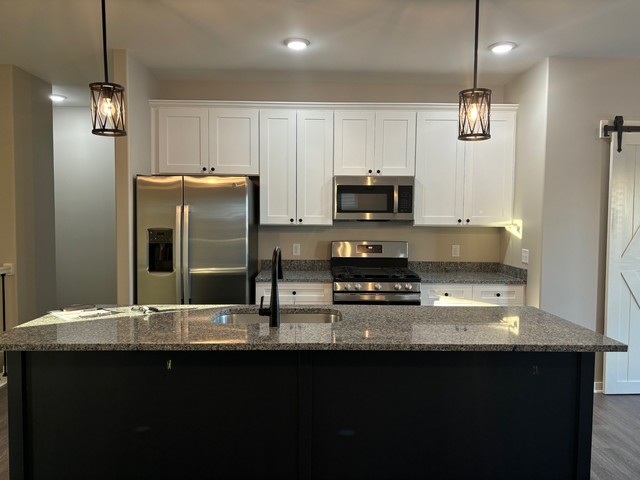 609 Anjali Court, Unit L Sycamore, IL 60178 - Photo 5 of 20 a kitchen with stainless steel appliances granite countertop a sink a stove top oven a refrigerator and a granite counter tops