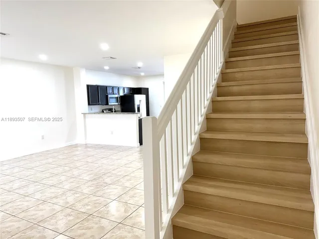 a large kitchen with a large counter top stainless steel appliances and cabinets