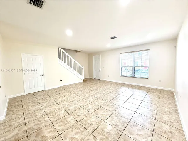 a view of a big room with wooden floor and a ceiling fan