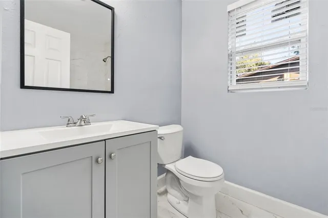 a bathroom with a toilet a sink a vanity and mirror