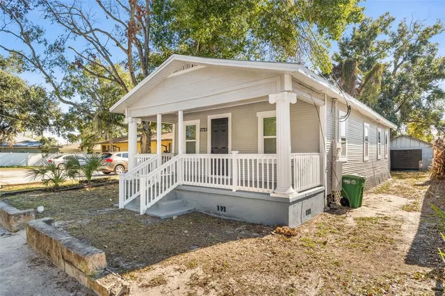 a view of a house with a yard and wooden fence
