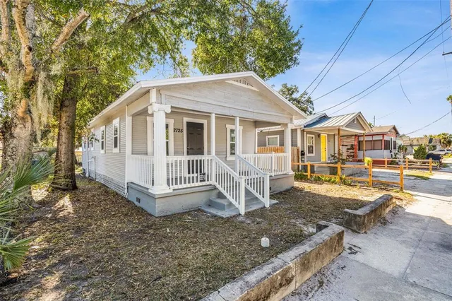 a view of a house with backyard and sitting area