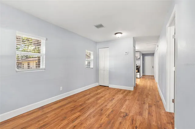 a view of a room with wooden floor and a window
