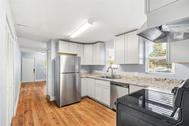 a kitchen with a refrigerator a sink and cabinets