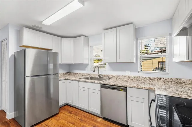 a kitchen with stainless steel appliances granite countertop a refrigerator sink and cabinets