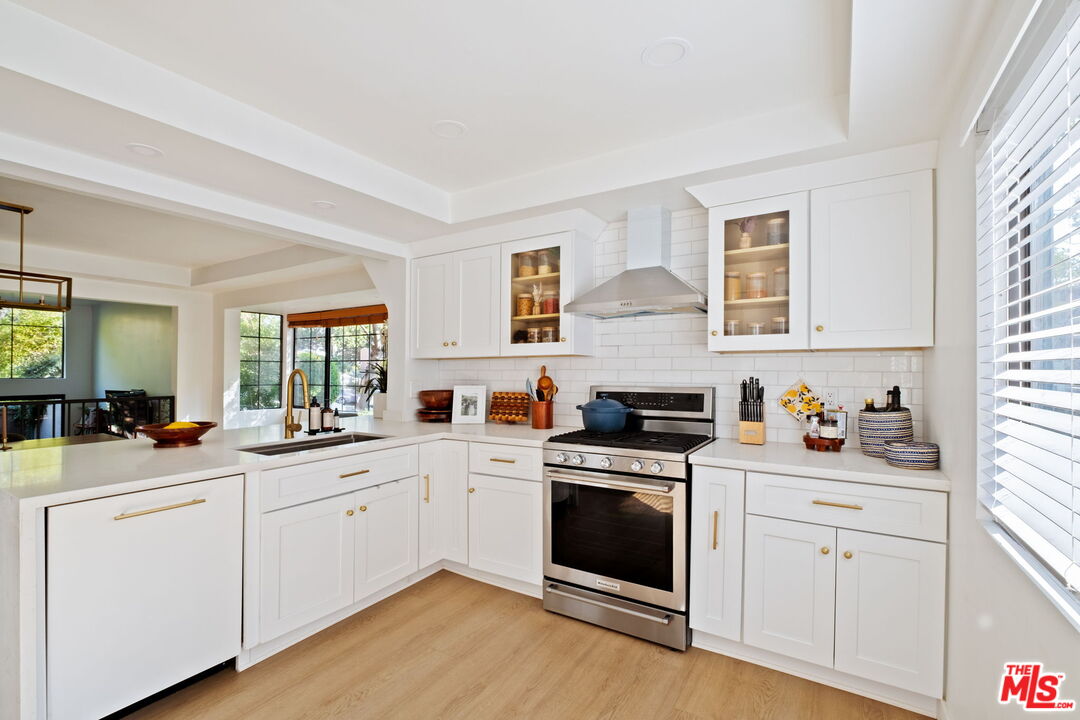 207 South Oakland Avenue, Unit A Pasadena, CA 91101 - Photo 15 of 41 a kitchen with white cabinets and white appliances