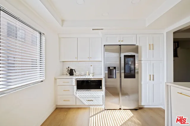 a kitchen with stainless steel appliances a refrigerator and a stove top oven