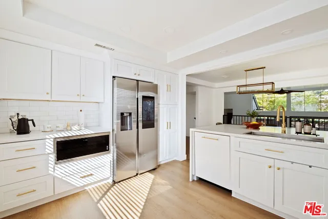 a kitchen with stainless steel appliances a refrigerator sink and cabinets
