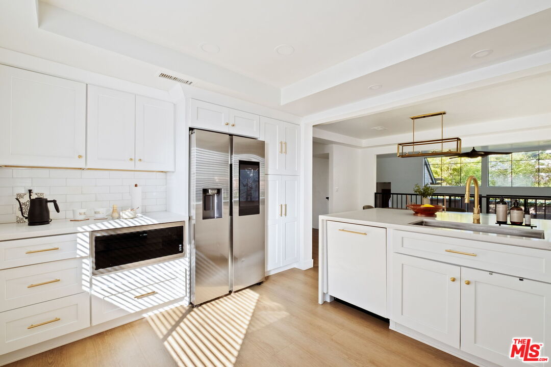 207 South Oakland Avenue, Unit A Pasadena, CA 91101 - Photo 17 of 41 a kitchen with stainless steel appliances a refrigerator sink and cabinets