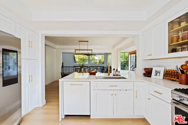 a kitchen with white cabinets and sink