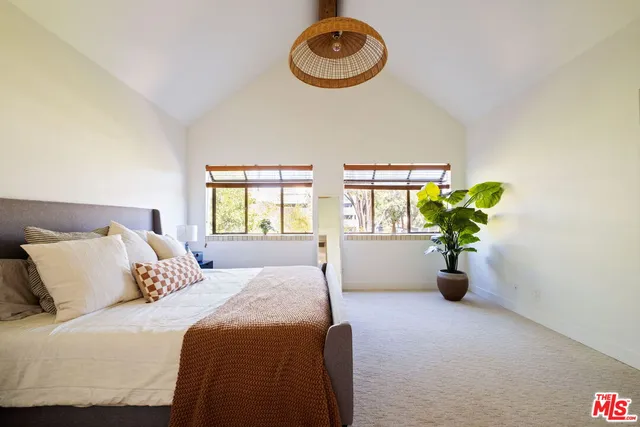 a bed sitting in a bedroom next to a window