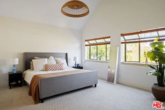 a bedroom with a bed and a potted plant