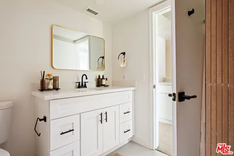 a bathroom with a sink vanity and a mirror