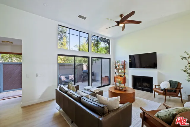 a living room with furniture fireplace and a large window