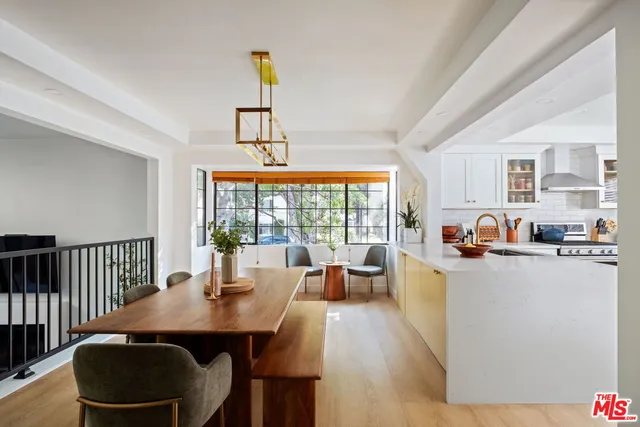 a dining room with furniture a chandelier and wooden floor