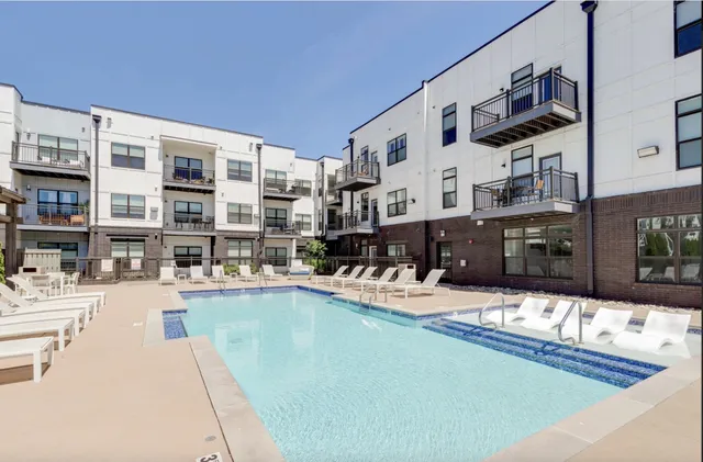 a living room with lots of furniture and a kitchen view