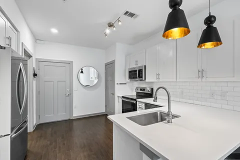 a kitchen with stainless steel appliances granite countertop a sink a refrigerator and a stove