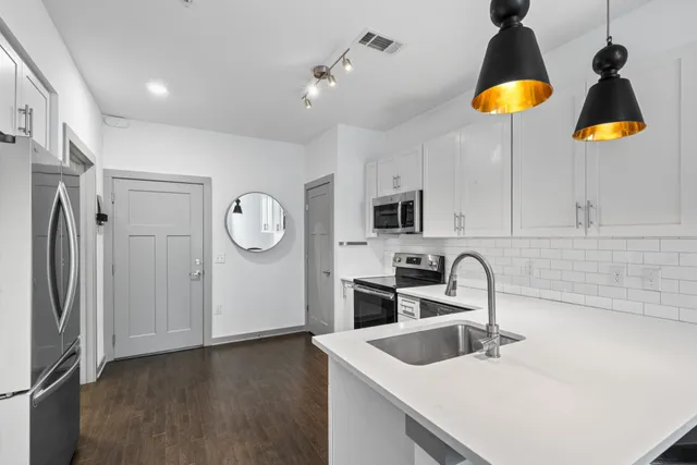 a kitchen with stainless steel appliances granite countertop a sink a refrigerator and a stove