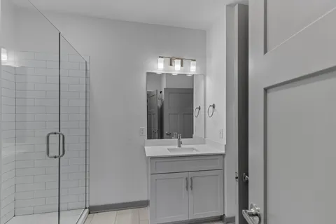 a bathroom with a shower sink and mirror