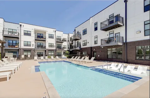 a living room with lots of furniture and a kitchen view