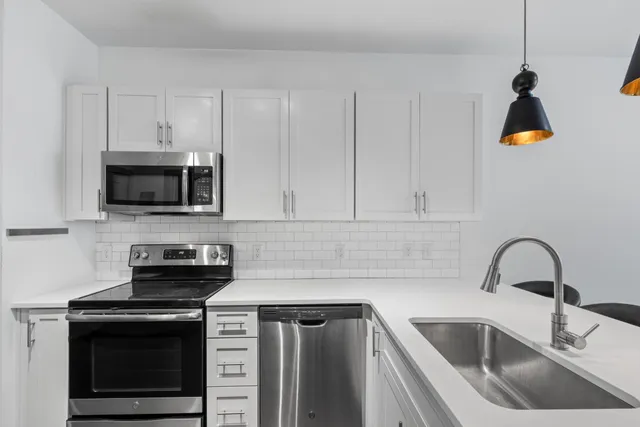 a kitchen with a sink stove and microwave