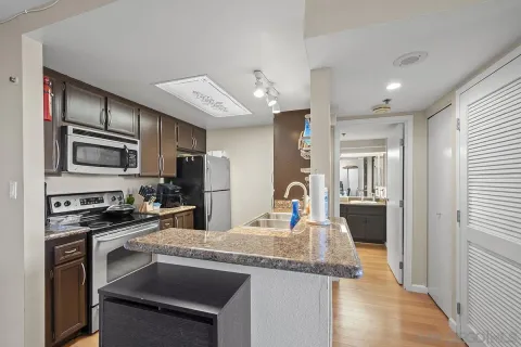 a kitchen with stainless steel appliances granite countertop a sink stove and refrigerator