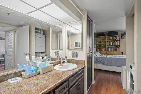 a en suite bathroom with a granite countertop sink and a mirror