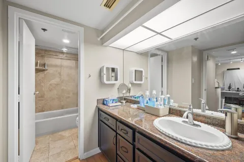 a bathroom with a granite countertop sink mirror and shower