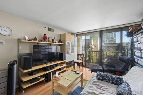 a living room with furniture a flat screen tv and a floor to ceiling window