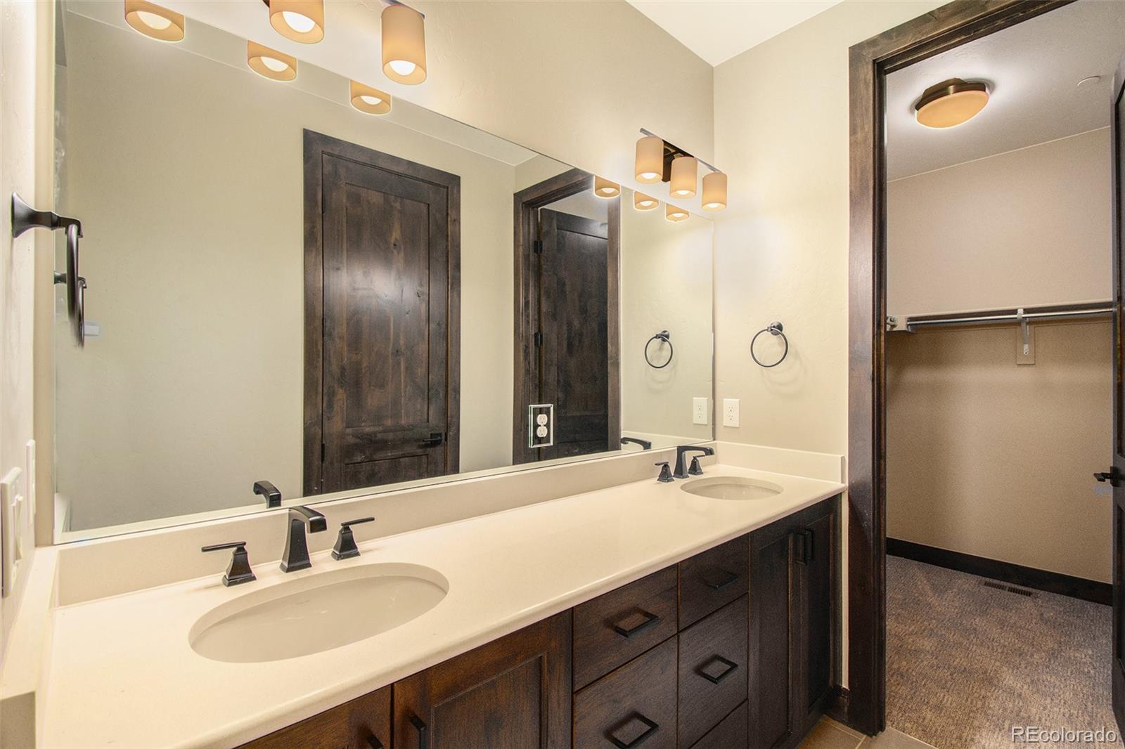 69 High Grove Loop Winter Park, CO 80482 - Photo 14 of 21 a bathroom with a double vanity sink a mirror and a shower