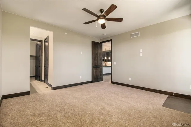 an empty room with closet and a ceiling fan