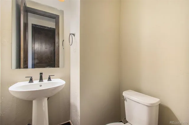 a bathroom with a sink toilet and mirror