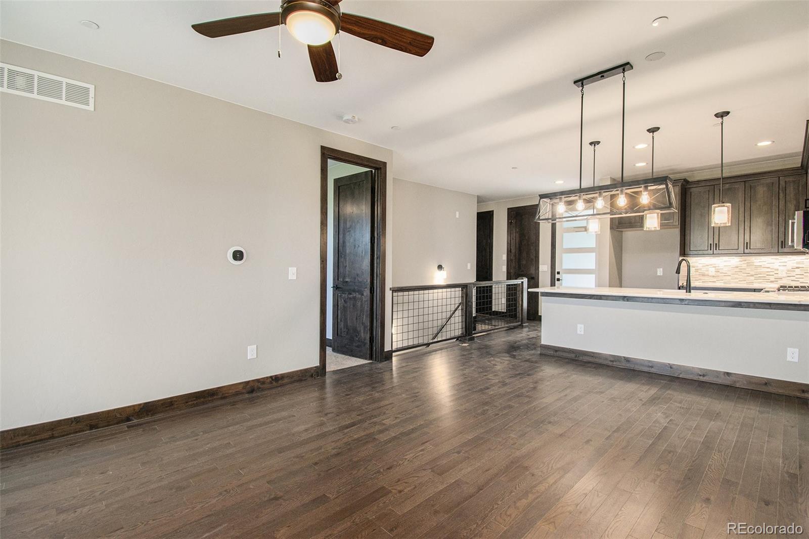 69 High Grove Loop Winter Park, CO 80482 - Photo 18 of 21 an empty room with wooden floor kitchen view and windows